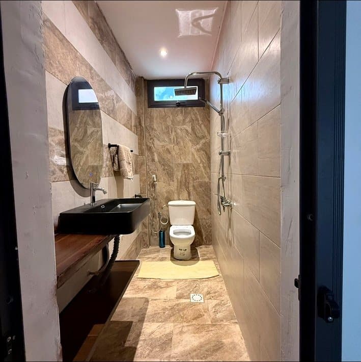 Salle de bain avec douche pluie et finitions en marbre
